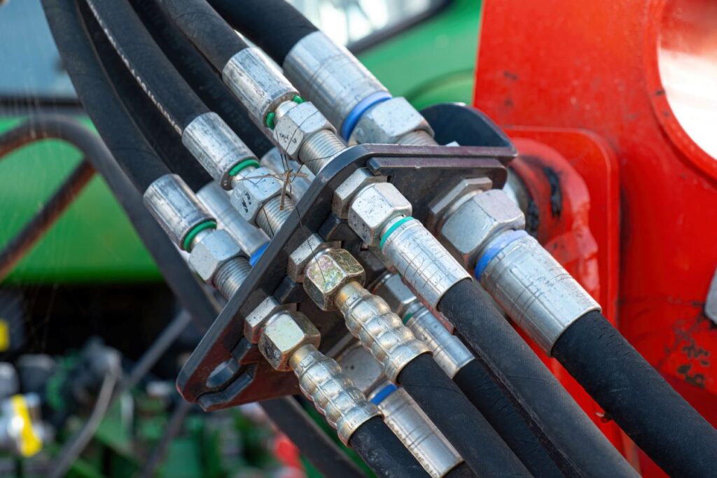 Detailaufnahme mehrerer verbundener Industrieschlaeuche an einer Hydraulikanlage in der Industrie