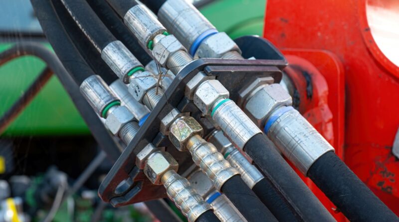 Detailaufnahme mehrerer verbundener Industrieschlaeuche an einer Hydraulikanlage in der Industrie